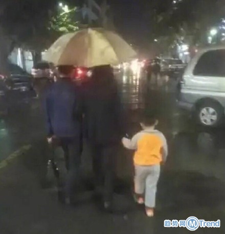 妈妈把孩子举起来挡雨 绝对是亲生的